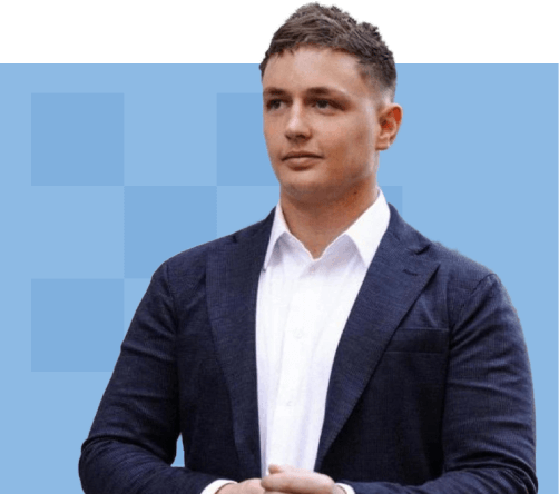 Kyle Hunt in a dark suit and white shirt stands confidently, with arms crossed