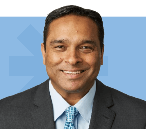 Neeraj Sharma of a smiling wearing a dark suit and blue tie